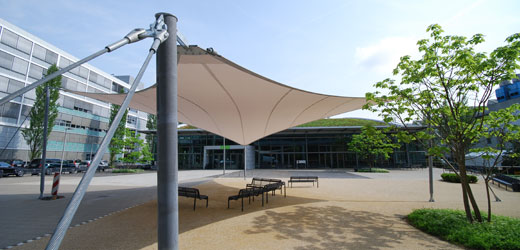A three-dimensional membrane serves as a shade sail and weather protection roofing.