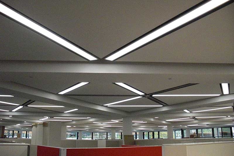 Hier sehen Sie akustisch wirksames Material mit Licht kombiniert an der Decke eines Unternehmens.